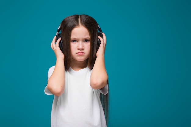 Schoonheidsmeisje in T-stukoverhemd en oortelefoons met lang haar