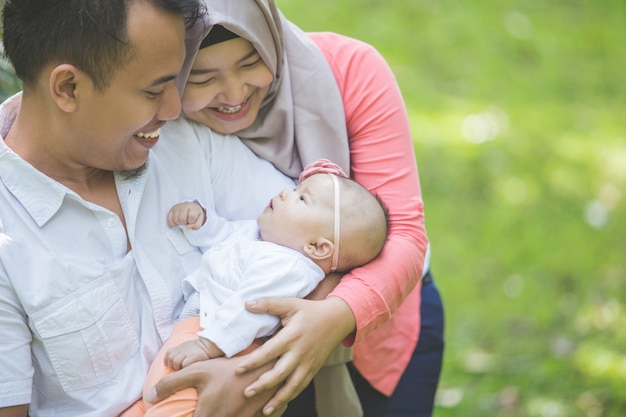 Schoonheidsmoeder en vader met hun pasgeboren baby in het park