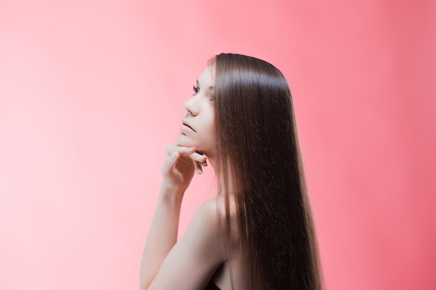 Schoonheidsportret van brunette met perfect haar op een roze achtergrond