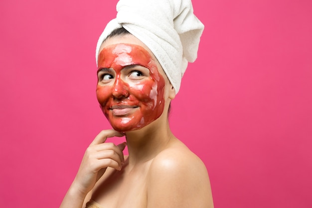 Schoonheidsportret van vrouw in witte handdoek op hoofd met gouden voedend masker op gezicht