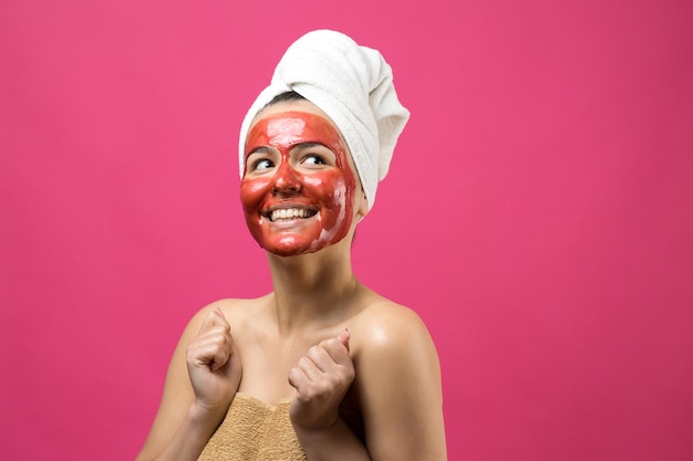 Schoonheidsportret van vrouw in witte handdoek op hoofd met gouden voedend masker op gezicht