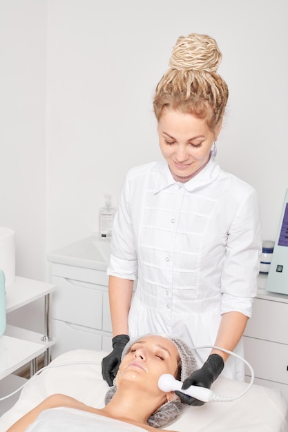 Schoonheidsspecialist maakt RF-lifting voor verjonging vrouw gezicht anti aging cosmetische procedure