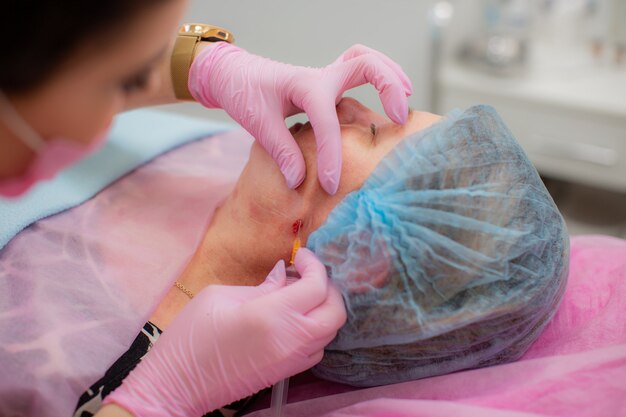 Schoonheidsspecialiste brengt een subcutane injectie van Botox