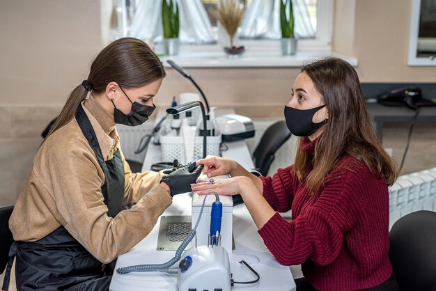 Schoonheidsspecialiste doet manicure vrouwelijke klant in nagelsalon
