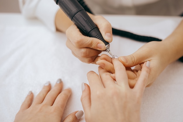 Schoonheidsspecialiste handen tijdens een manicure