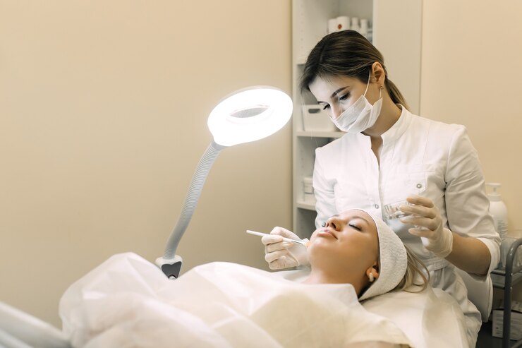 schoonheidsspecialiste past cosmetisch product toe op geduldige vrouw met borstel