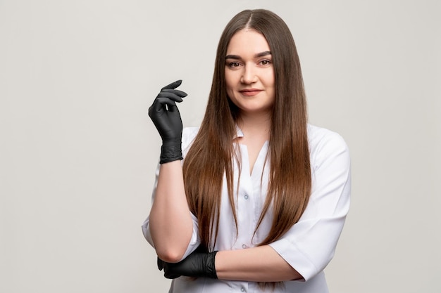 Schoonheidsspecialiste portret zelfverzekerde vrouw zwarte handschoenen