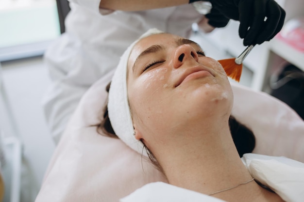 Schoonheidsspecialiste reinigt de huid van mooie vrouw met een spons Perfecte reiniging spa behandeling huidverzorging gezicht