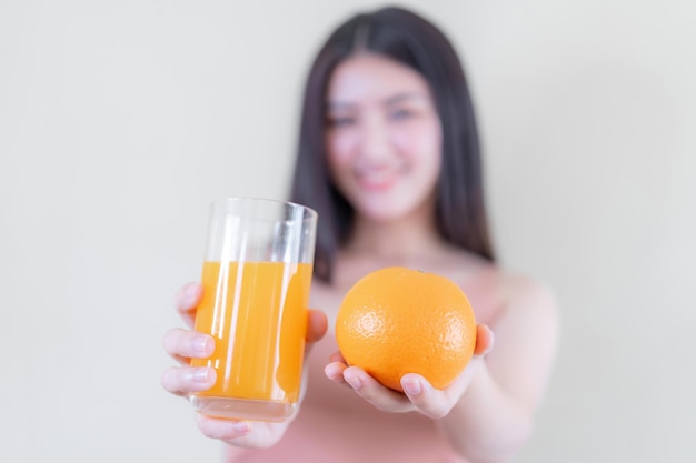 Schoonheidsvrouw Aziatisch schattig meisje voelt zich gelukkig met oranje fruit en jus d'orange voor een goede gezondheid op de roze achtergrond levensstijl schoonheidsvrouw