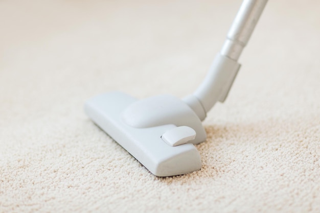 schoonmaak- en huisconcept - close-up van mannelijk stofzuigend tapijt
