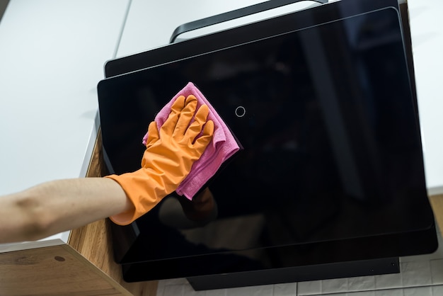 Schoonmaak keuken. Vrouwelijke hand wassen afzuigkap met spons. Huiswerk