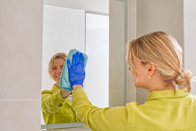Schoonmaakbedrijf hotel meid microvezeldoek wassen schoonmaken een spiegel huishoudelijk serviceconcept