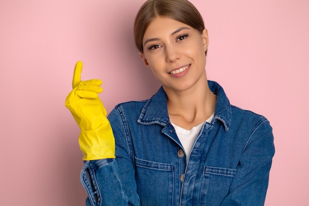 Schoonmaakbedrijf werknemer in overall gele handschoenen en schoonmaakspullen