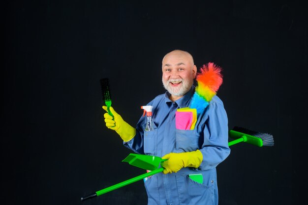 Schoonmaaktijd lachende man in uniform met schoonmaakapparatuur huishoudelijke dienst professionele schoonmaak