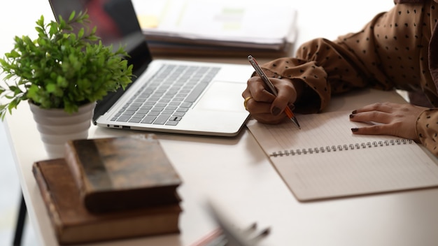 Schoot vrouw schrijven op laptop op tafel met laptop