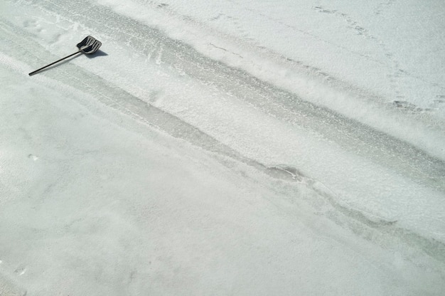 Schop om sneeuw schoon te maken ligt op de bevroren rivier