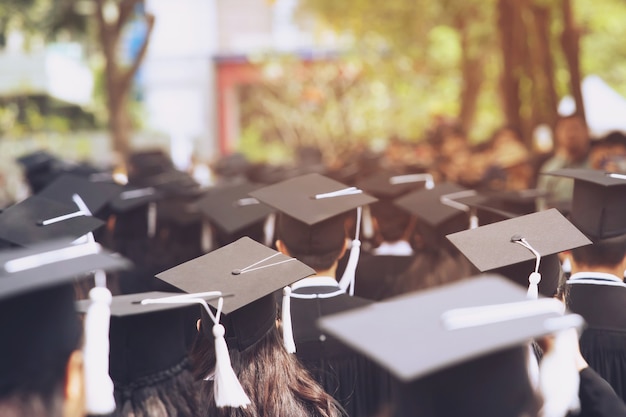 Schot van afstudeerhoeden tijdens aanvangssucces afgestudeerden van de universiteit, felicitatie conceptonderwijs.