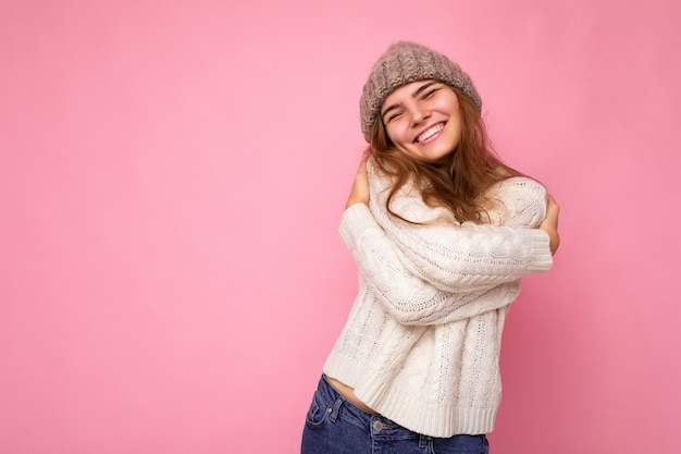 Schot van mooie gelukkig positief lachende jonge brunette vrouw geïsoleerd over roze achtergrond muur