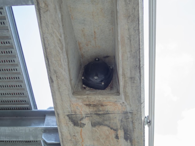 Schot vanuit een laag standpunt. Grote moerkap (zwart) onder de betonnen balk (spoorbaan van de elektrische trein).