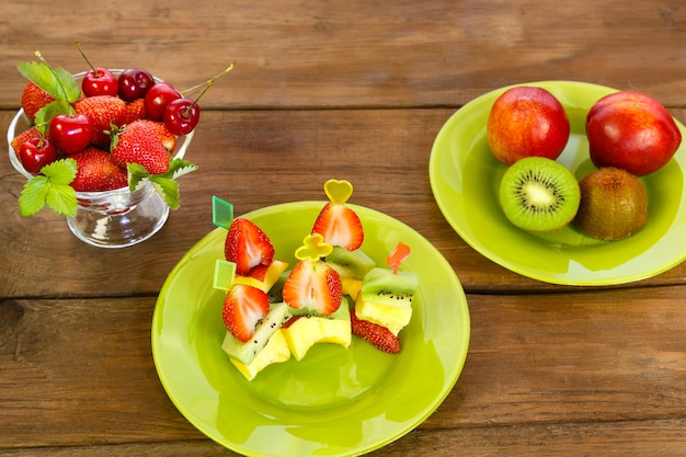 Schotel met canapés van perziken, kiwi en aardbeien.