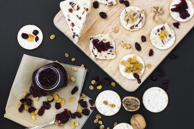 Schotel met crackers en cranberrykaas met walnoten-rozijnenjam en gedroogde cranberry