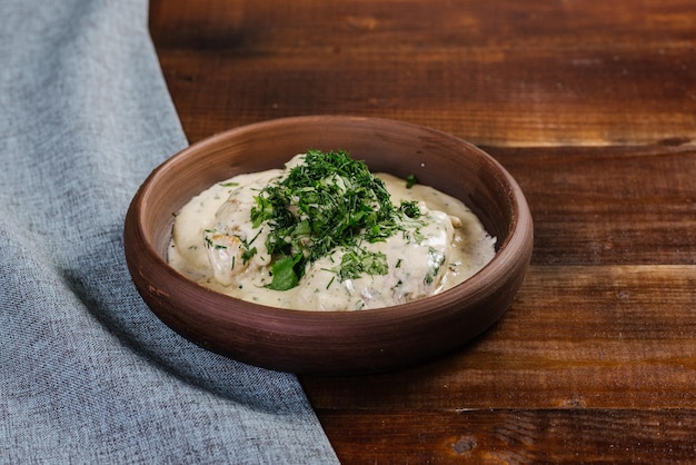 Schotel met gehakt vlees met saus en kruiden op de houten achtergrond