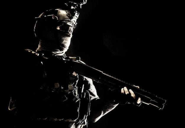 Schouder portret van leger elite troepen soldaat antiterroristische tactische team wit jachtgeweer helm met warmtebeeldcamera verbergen gezicht achter masker gewapend geweer met optische reikwijdte studio schieten op zwart