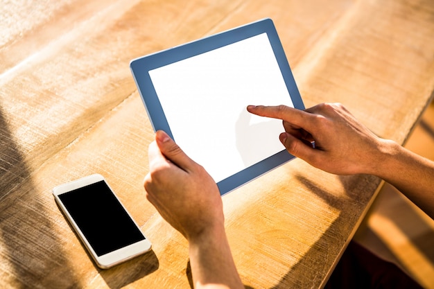 Schoudermening van de toevallige mens die tablet in bureau gebruiken