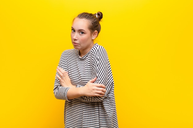 schouderophalend, verward en onzeker, twijfelend met gekruiste armen en verbaasde blik