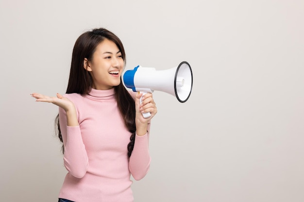 Schreeuw hardop met megafoon Jonge mooie aziatische vrouw vrouw kondigt met een stem aan over promoties en advertenties voor producten tegen een gereduceerde prijs Winkel- en modeconcept