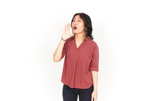 Schreeuwen hardop met de handen voor de mond van mooie Aziatische vrouw geïsoleerd op een witte achtergrond