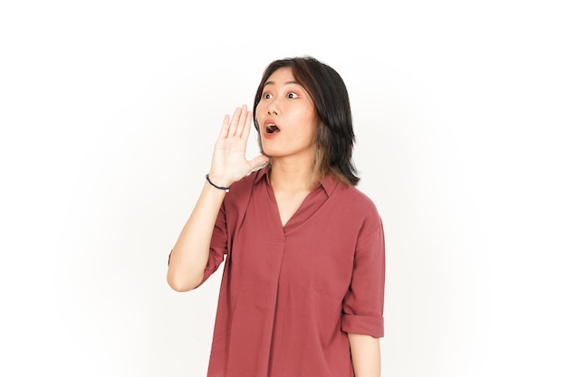 Schreeuwen hardop met de handen voor de mond van mooie aziatische vrouw geïsoleerd op een witte achtergrond