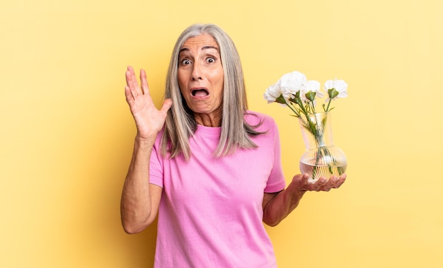 Schreeuwen met de handen in de lucht, woedend, gefrustreerd, gestrest en overstuur voelen met decoratieve bloemen