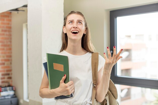 schreeuwend met de handen in de lucht. studente aan de universiteit