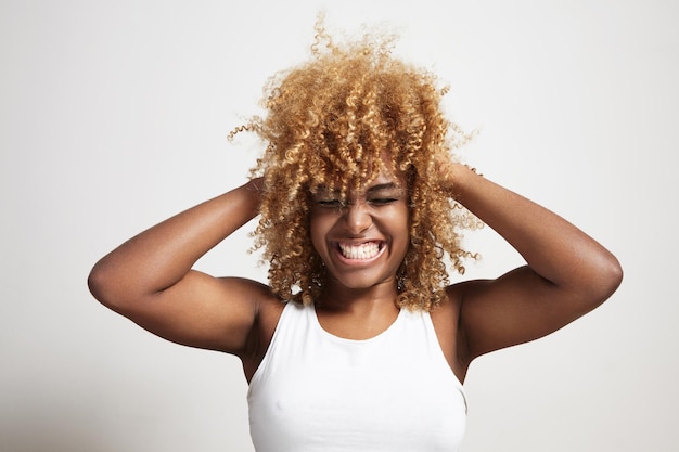Schreeuwende zwarte vrouw comprimeert het blonde afro-haar