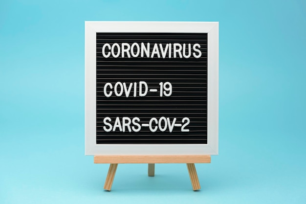 Schrijfbord coronavirus covid19 en sarscov2 geïsoleerd op blauwe achtergrond