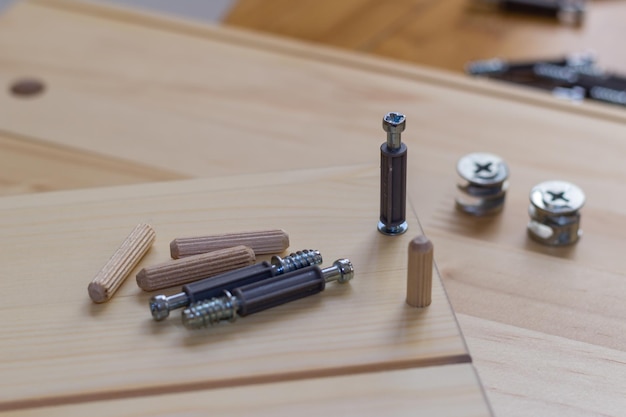 Schroef wordt geschroefd in hout, pluggen en meubelaccessoires close-up met kopieerruimte
