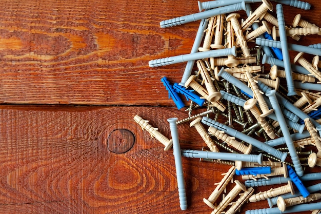 Schroeven en plastic pluggen op een houten ondergrond Selectieve aandacht