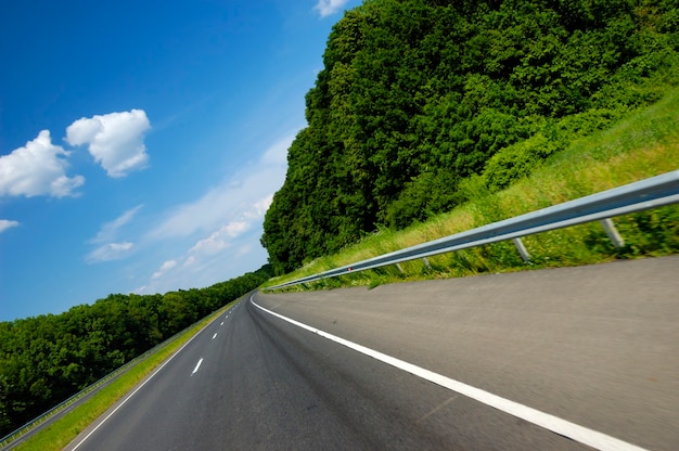 Schuine hoekopname is een gladde snelweg omgeven door prachtige zomerse natuur