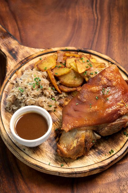 写真 シュワインシャクス ドイツの伝統的な豚肉のノックル 酸菜とジャガイモの食事