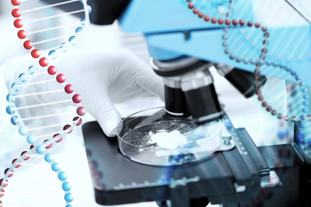 Photo science, chemistry, biology, medicine and people concept - close up of scientist hand with microscope and powder test sample making research in clinical laboratory over dna molecule structure