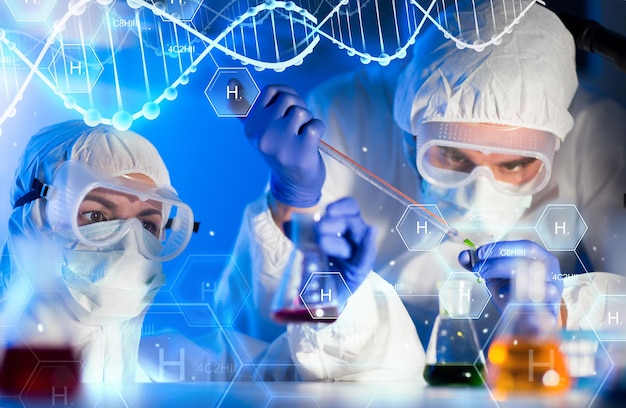 science, chemistry, biology, medicine and people concept - close up of scientists with pipette and flasks making test in clinical laboratory over hydrogen chemical formula and dna molecule structure