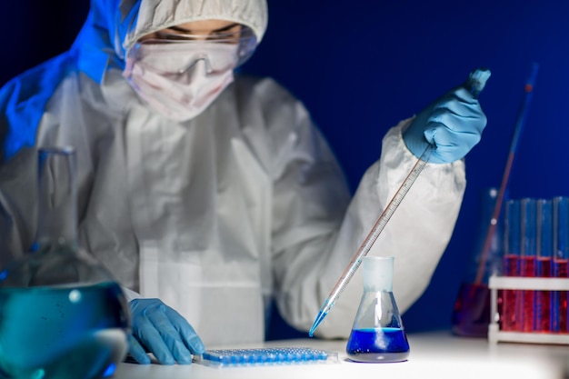 과학, 화학, 생물학, 의학 및 사람들의 개념 - 임상 실험실에서 피펫과 플라스크를 만드는 테스트 또는 연구를 가진 젊은 여성 과학자의 클로즈업
