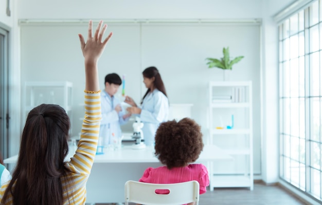 In the science classroom an Asian child scientist experimenting with scientific formulas