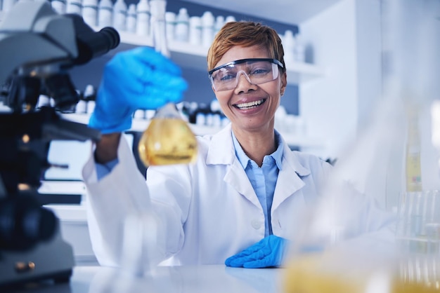 Science liquid and black woman in laboratory with smile for research medical study and experiment Healthcare pharmaceutical and female scientist with glass beaker for sample medicine and vaccine