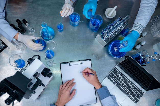 Science and medicine, scientist analyzing and dropping a sample into a glassware, experiments containing chemical liquid in laboratory on glassware, DNA structure, innovative and technology.