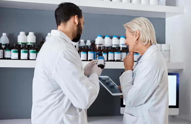 Science medicine and team with tablet in laboratory for vaccine medical report and research Pharmacy healthcare and scientists reading label of medication for data analysis results and study