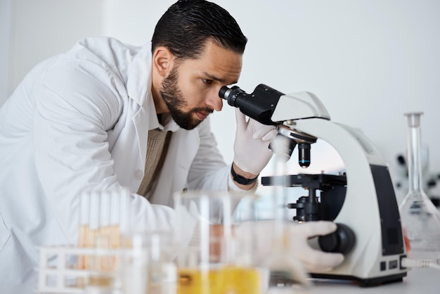 Science microscope and research with a doctor man at work in a laboratory for innovation or development Medical analytics and biotechnology with a male scientist working in a lab for breakthrough