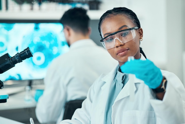 Science research and black woman with test tube in laboratory medical engineering and vaccine technology Biotechnology pharmaceutical study and medicine scientist or lab technician with solution