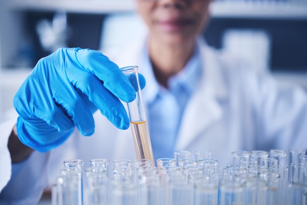 Science research and hand with test tube woman in laboratory with solution for vaccine and medical innovation Healthcare lab analytics and medicine female scientist holding pharmaceutical sample